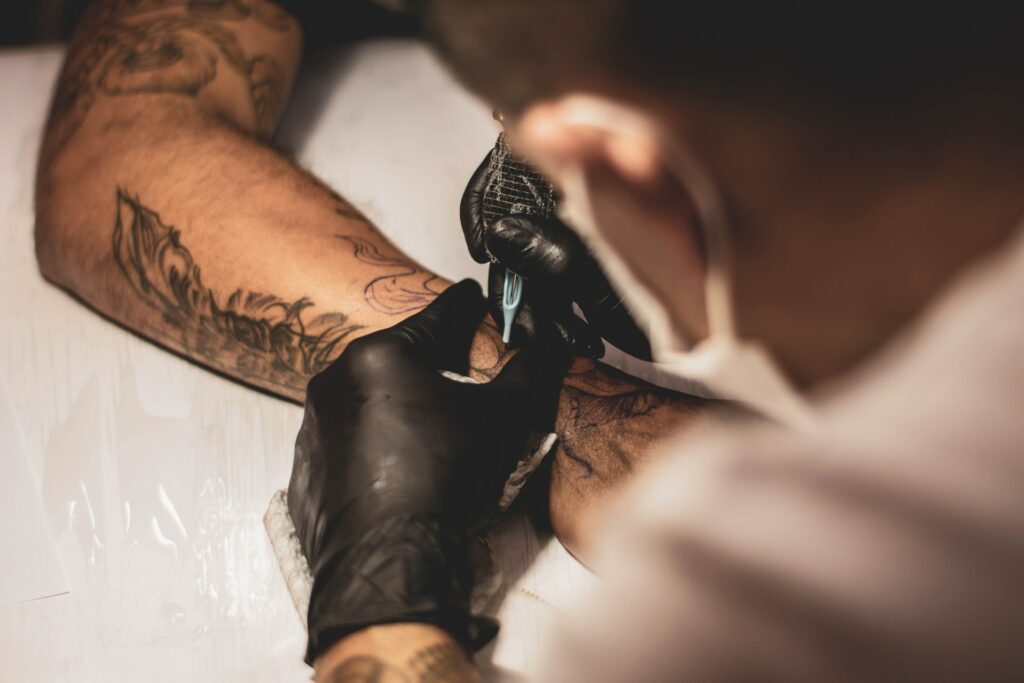 Shallow focus of a tattoo artist giving a tattoo on someone's arm