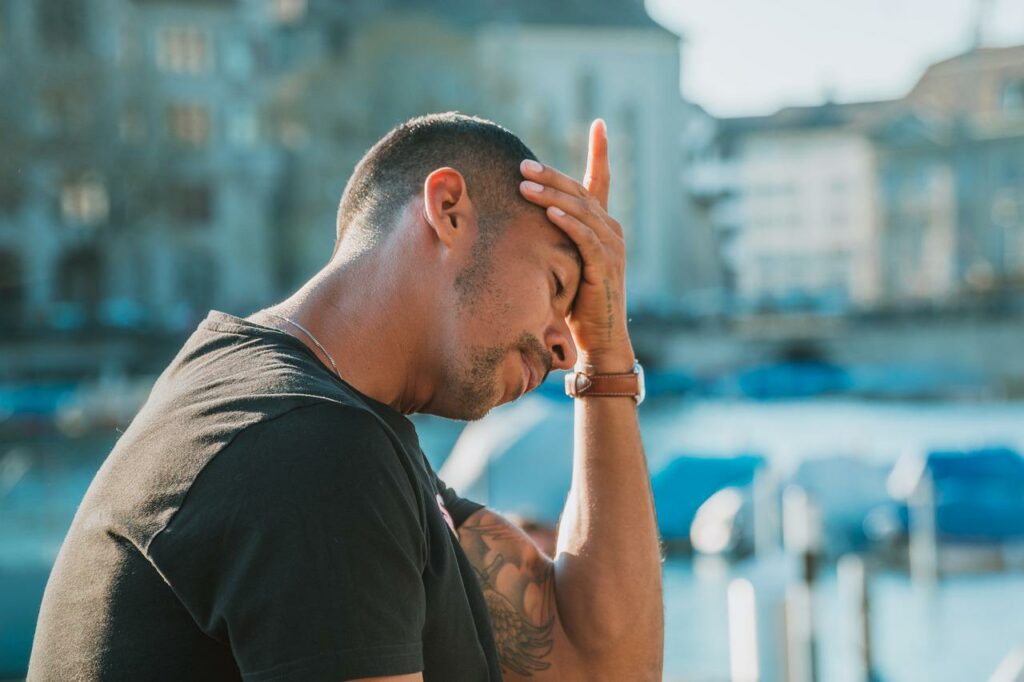 Person with their hand on their head experiencing a headache