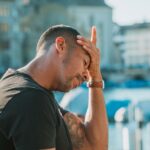 Person with their hand on their head experiencing a headache