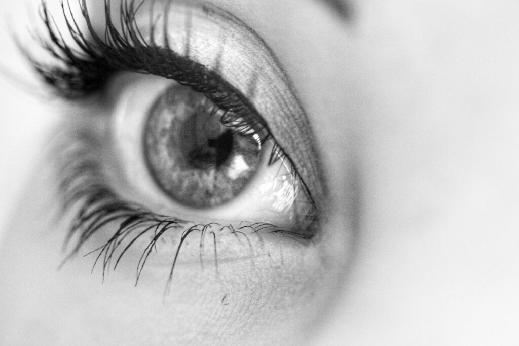 Black and white photo of an eye with long eyelashes.