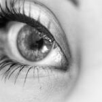 Black and white photo of an eye with long eyelashes.