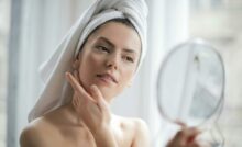 Selective Focus Portrait Photo of Woman With a Towel on Head Looking in the Mirror